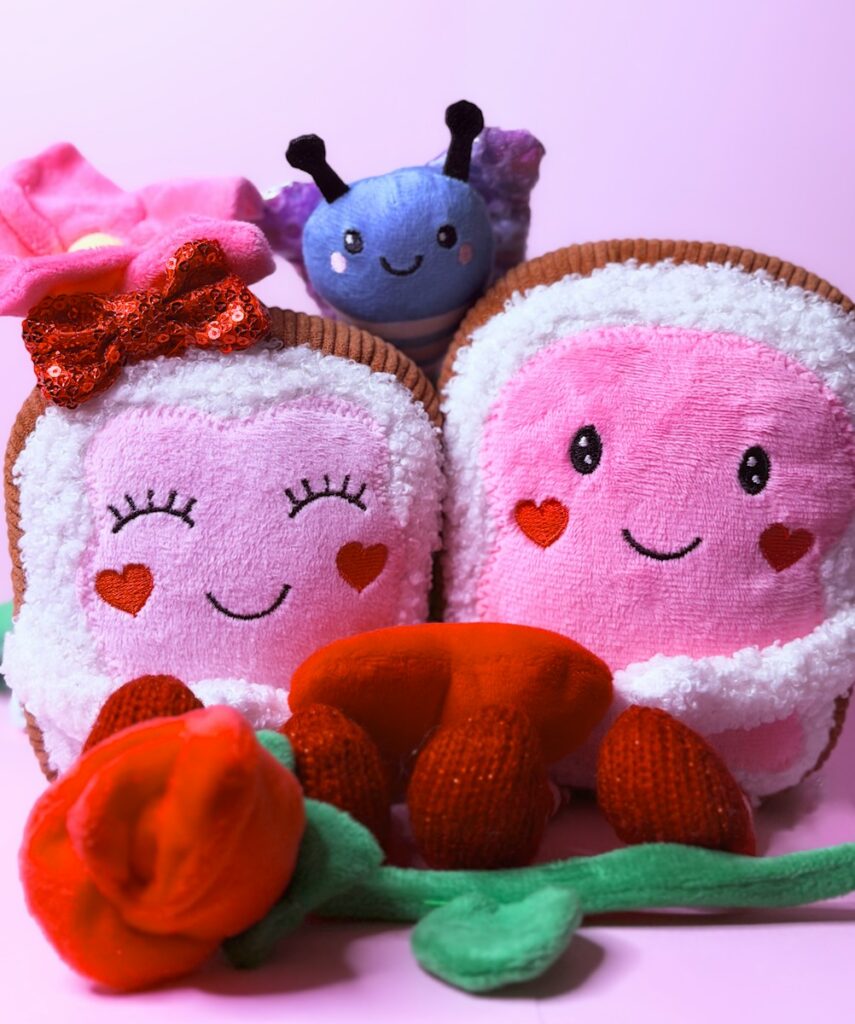 Two plush toast characters with a butterfly and rose.